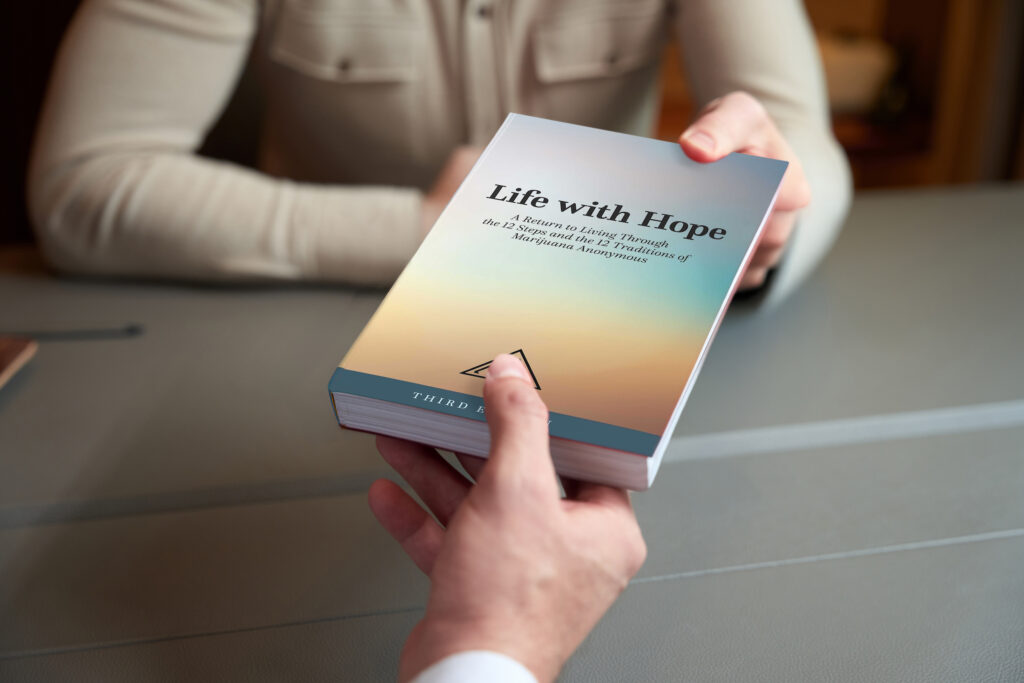 A person handing a copy of Life with Hope to another person