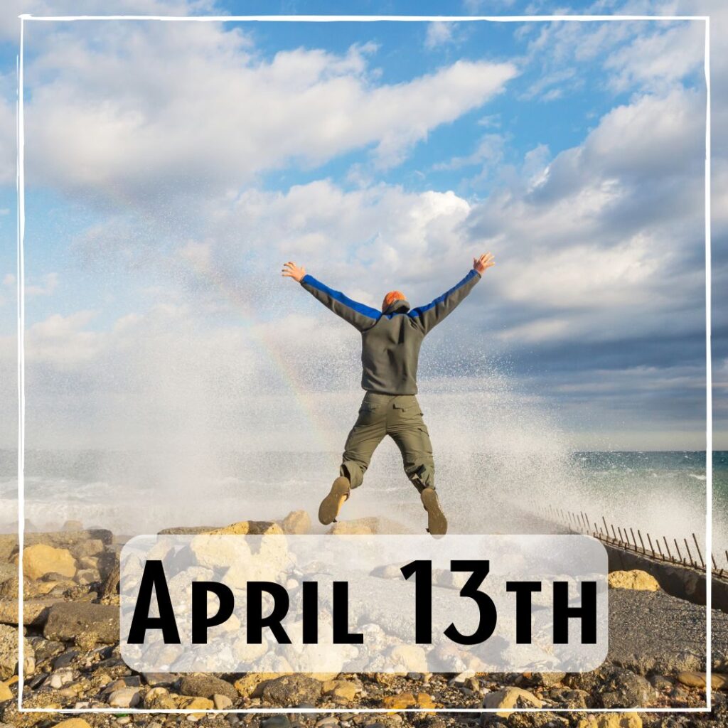 April 13th - a person standing with their legs and arms stretched out next to a sea spray blowhole