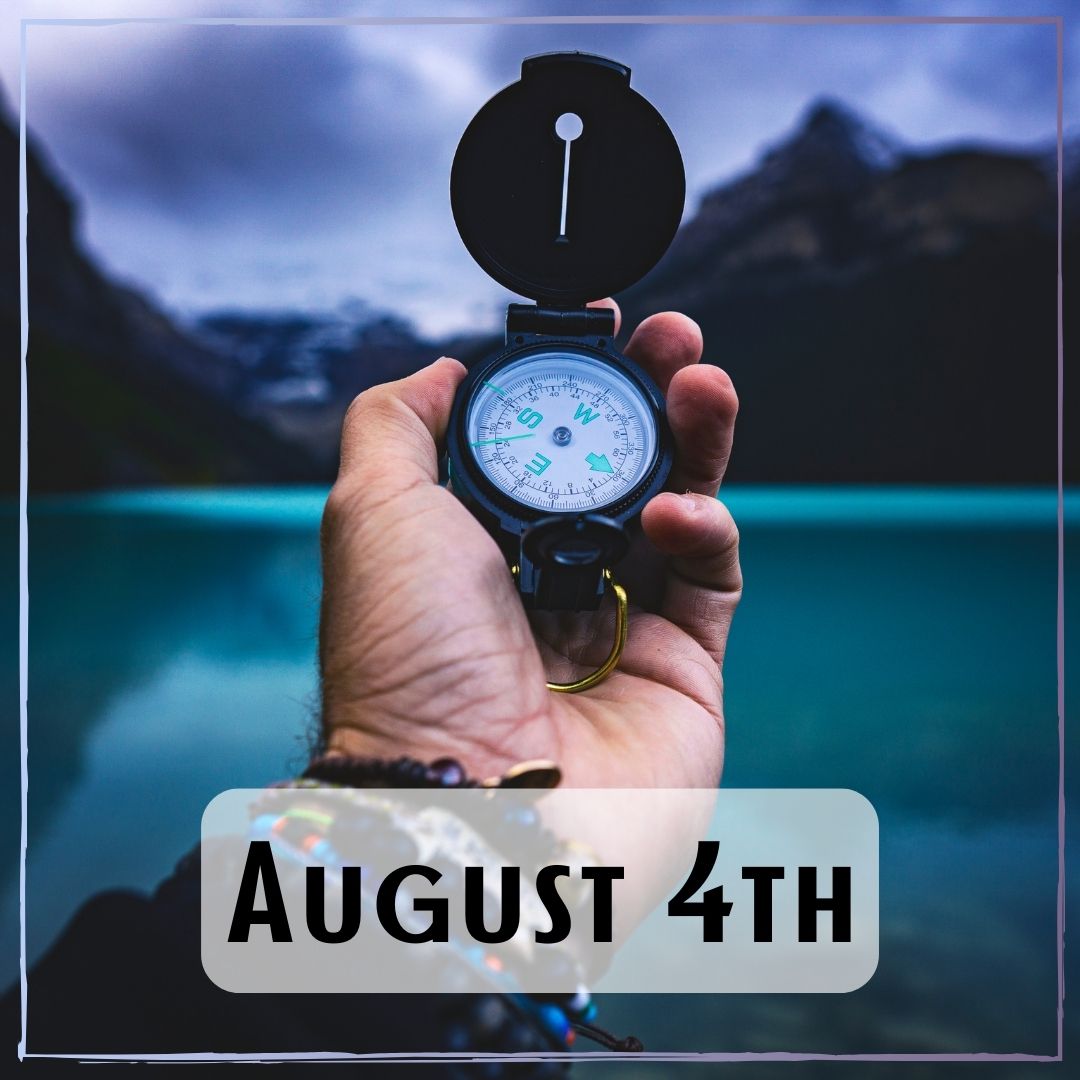 August 4th - a person holding a compass with a lake and mountain background