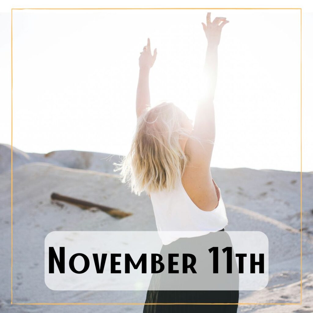 November 11th - a person with their arms reaching up, the sunlight is behind them, and there are sand dunes at the background