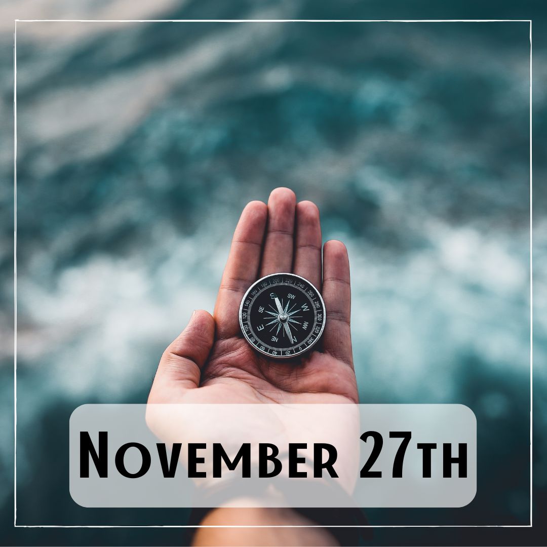 November 27th - a hand holding a compass over the water