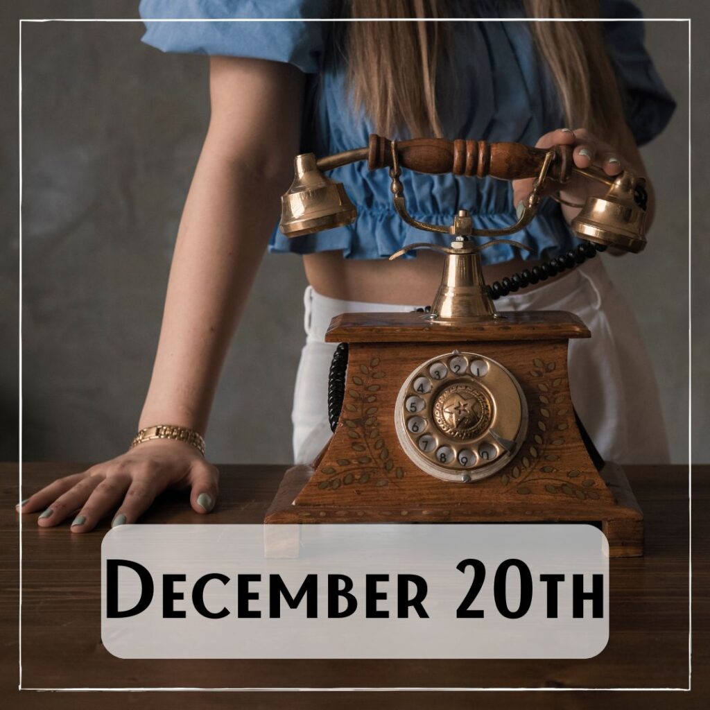 December 20th - a person standing next to an antique wooden rotary phone