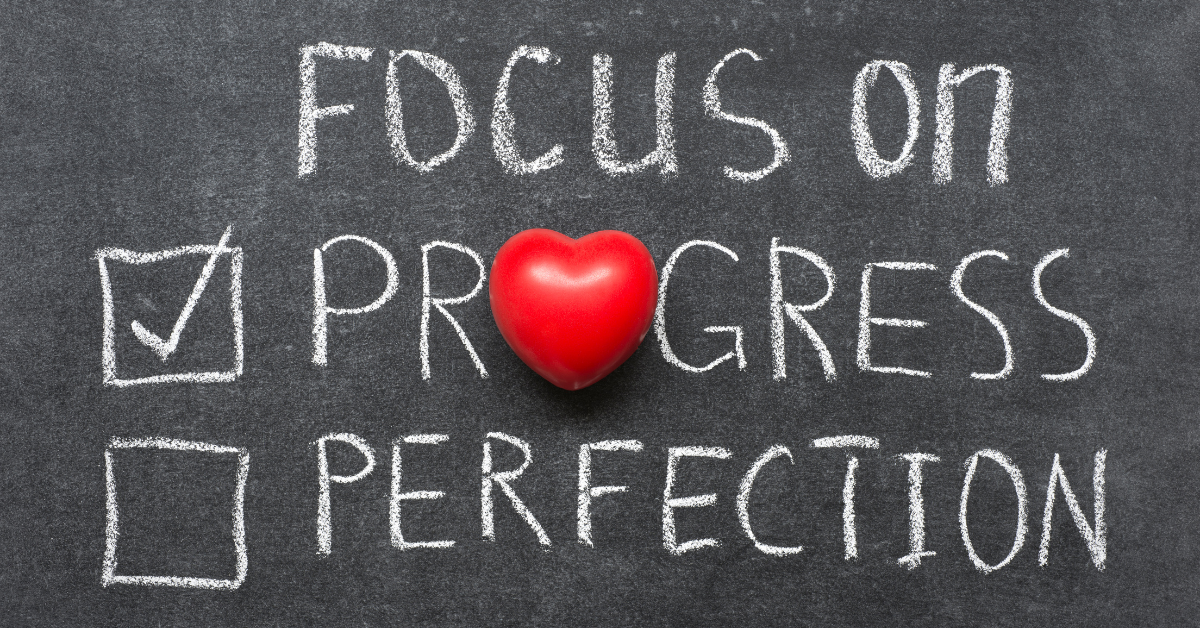 progress not perfection written on a chalkboard with a heart replacing the letter "O"