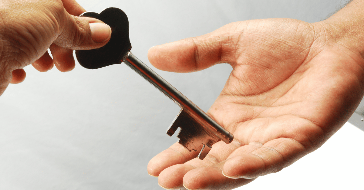 A person handing a key to someone else