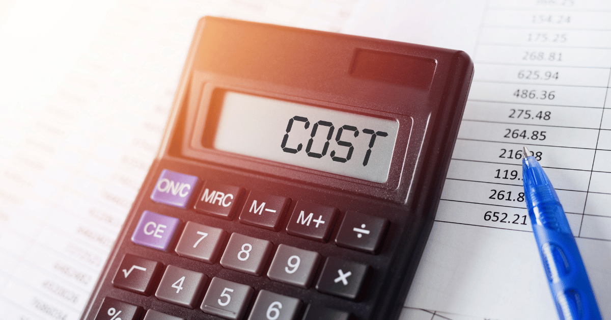 A picture of a calculator, pen ,and piece of paper. The calculator spells cost on it