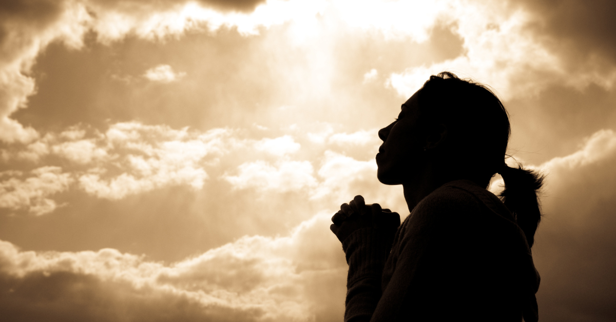 shadowed person with clouds behind them