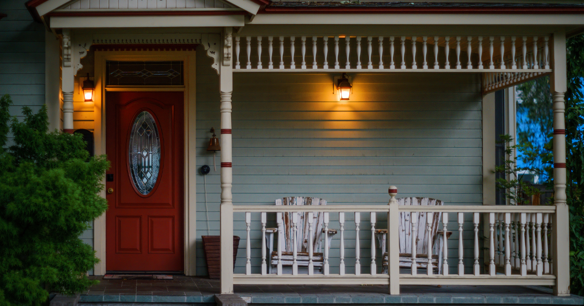 a front porch with the evening lights at dusk