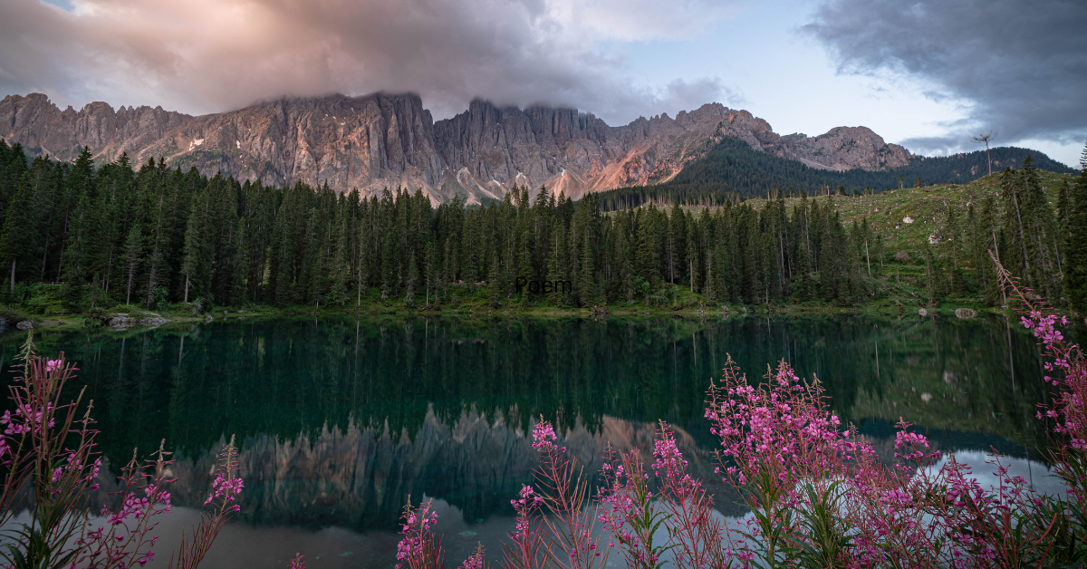 A quiet storm rolling in over a mountain behind an expansive lake