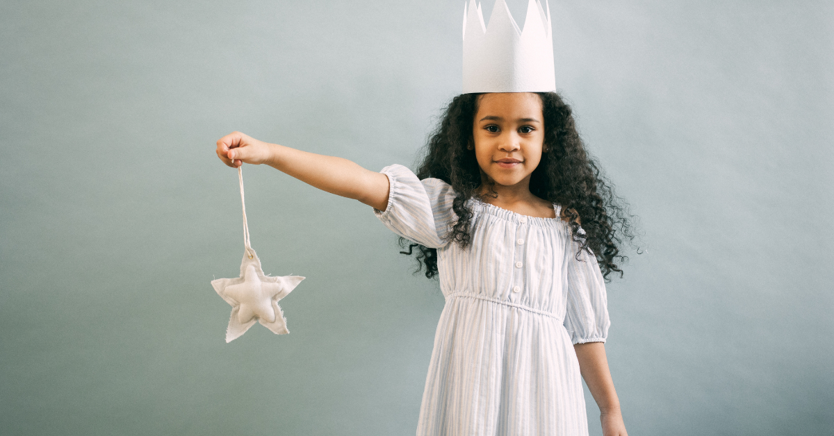 A very young and small individual in a princess costume