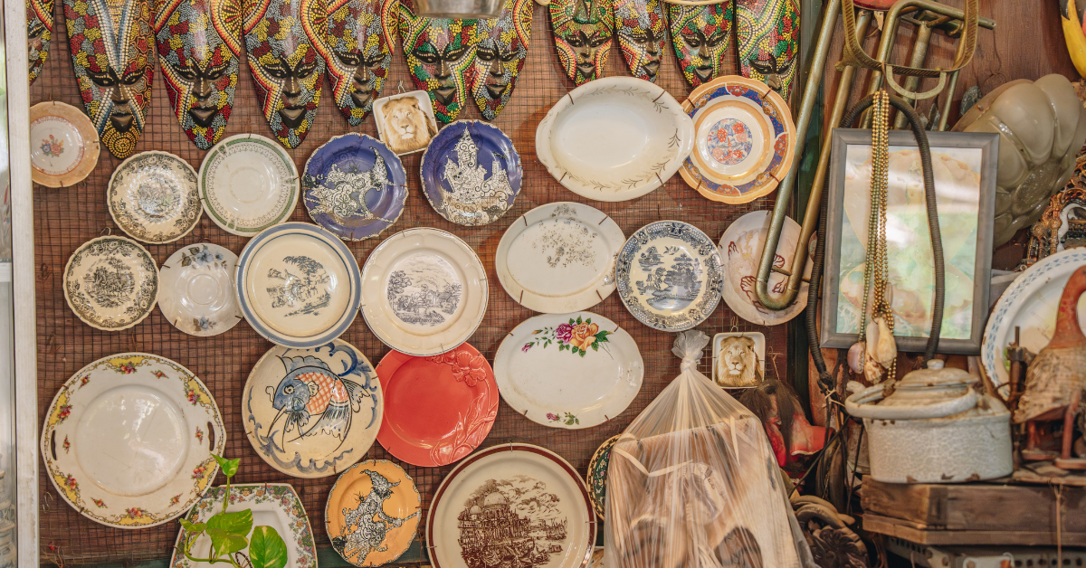 A selection of colorful vintage plates and other items hung on a wall